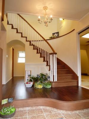 木製カーブ階段がお出迎えの玄関ホール。ホール床は重厚な雰囲気のアカシア無垢フロアー。