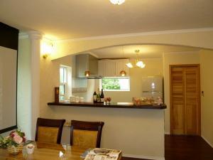 キッチンカウンターは、施主様イチオシの紫檀の1枚板。勝手口へのドアは、風通しを考えハーフルーバーに。